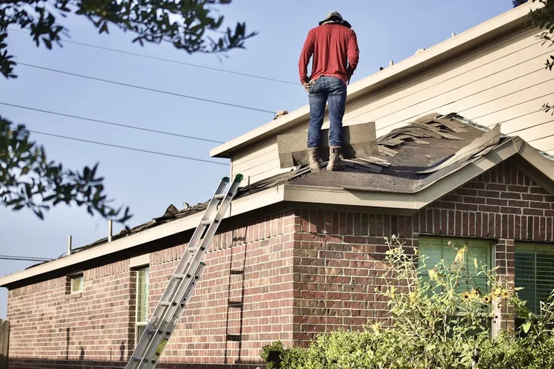 Professional roofer working on a residential roof in North Center